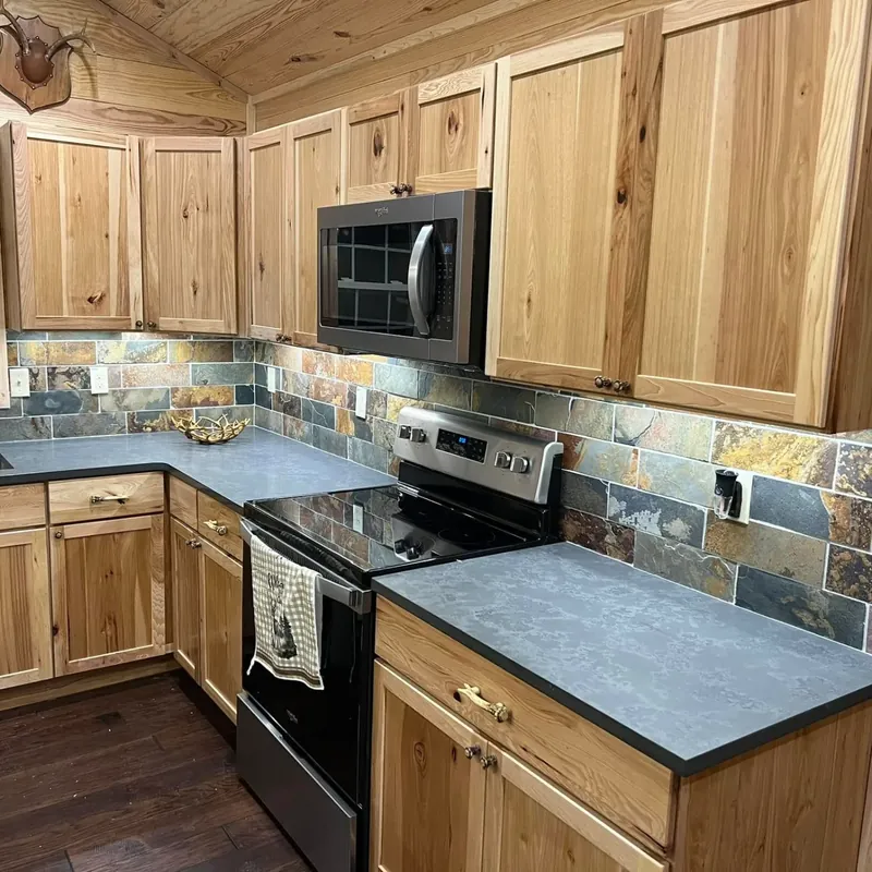 Wood cabinets, slate backsplash, dark counters, stainless appliances, C&A Roofing & Construction