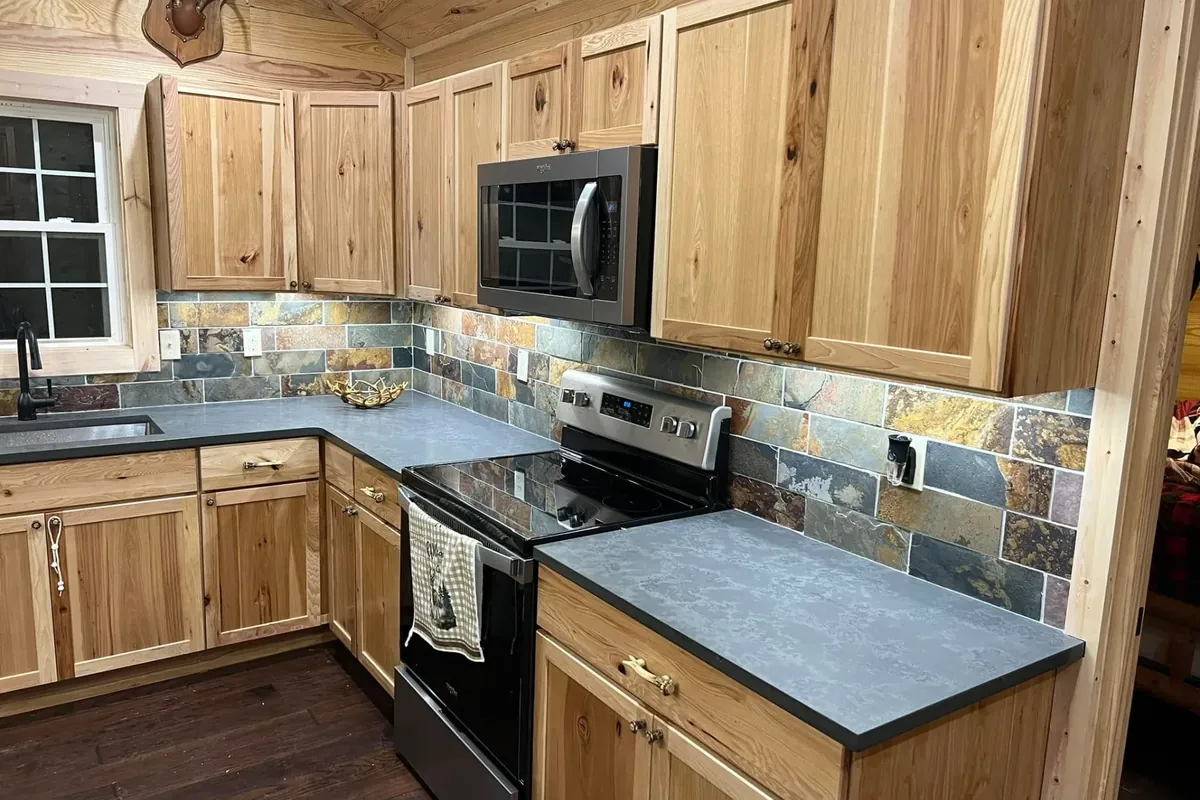 Wood cabinets, slate backsplash, dark counters, stainless appliances, C&A Roofing & Construction