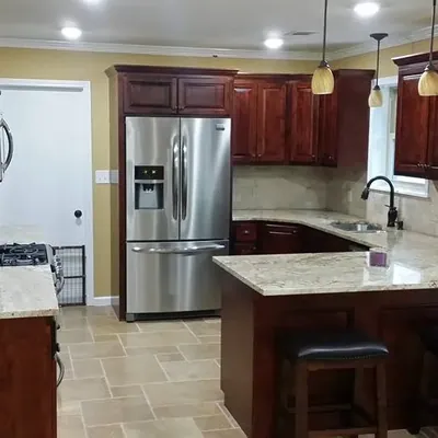 Dark cherry cabinets with island, stools and stainless fridge, C&A Roofing & Construction