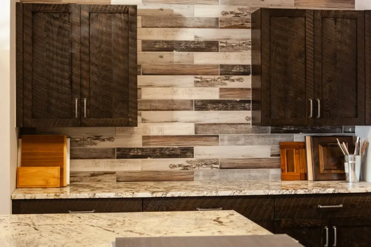Dark rustic cabinets on multi-tone wood plank wall, granite counters, C&A Roofing & Construction
