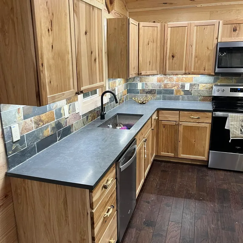 Rustic wood cabinets, slate backsplash, dark counters, C&A Roofing & Construction