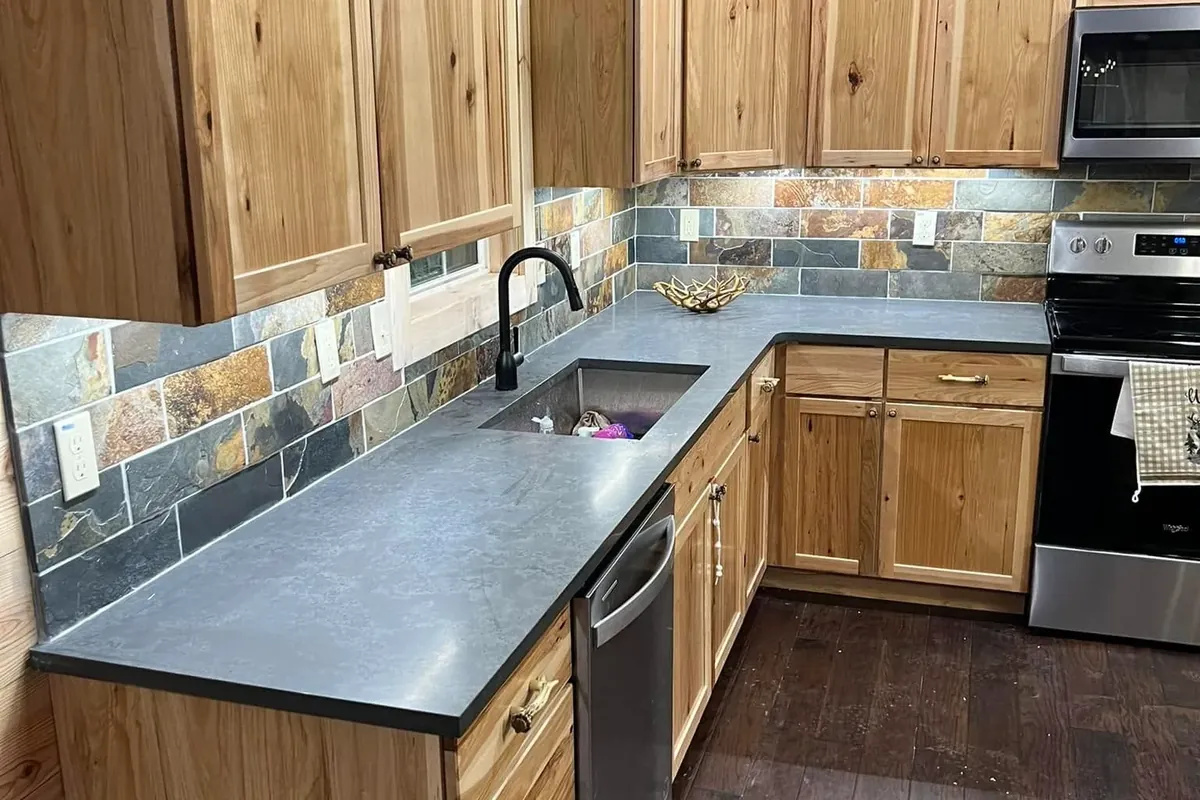 Rustic wood cabinets, slate backsplash, dark counters, C&A Roofing & Construction