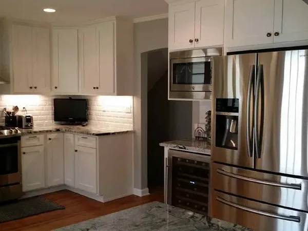 White cabinets with stainless range, microwave and fridge, C&A Roofing & Construction
