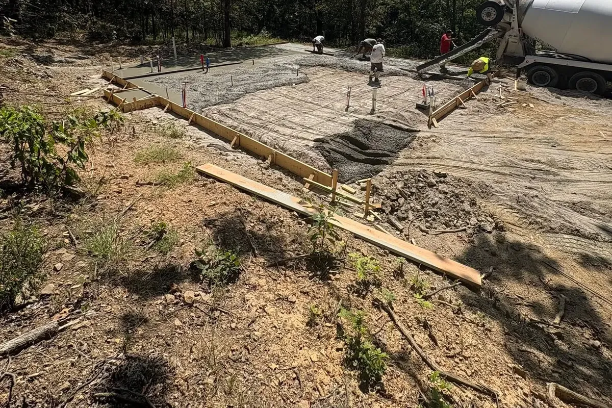 Concrete pour in foundation forms with mixer truck behind, C&A Roofing & Construction