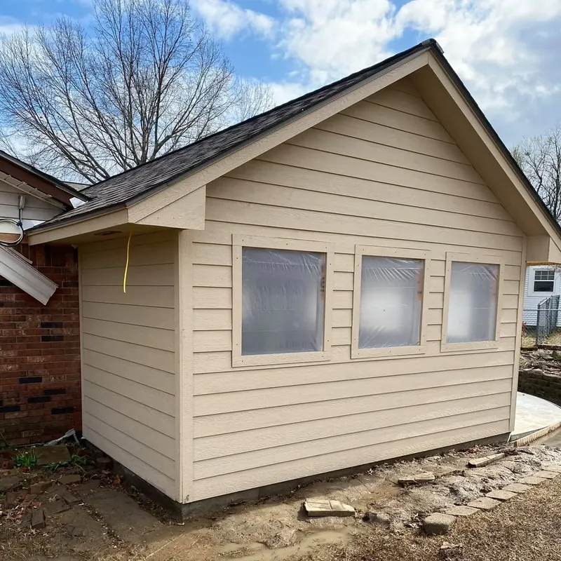 New tan-sided addition with shingle roof attached to brick house, C&A Roofing & Construction