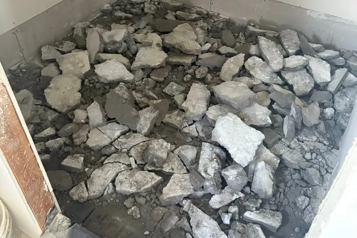 Bathroom shower pan torn out, pile of tile debris, C&A Roofing & Construction