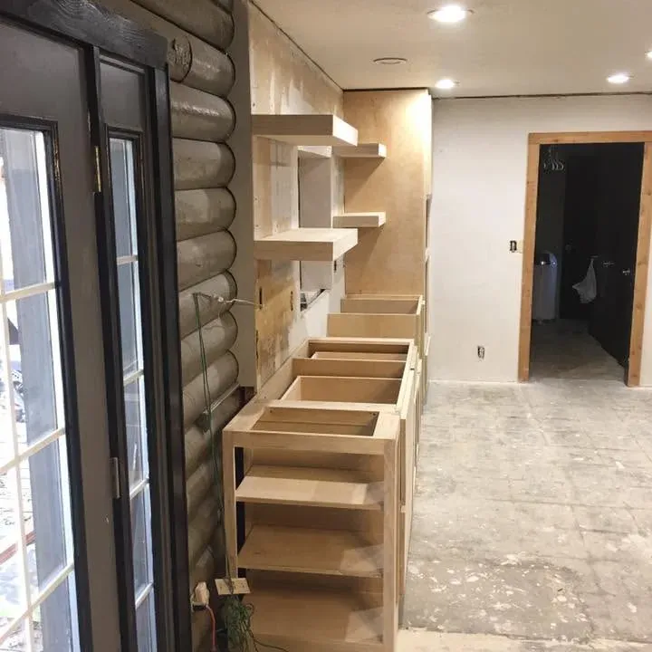 Unfinished kitchen cabinet boxes and floating shelves in log home, C&A Roofing & Construction