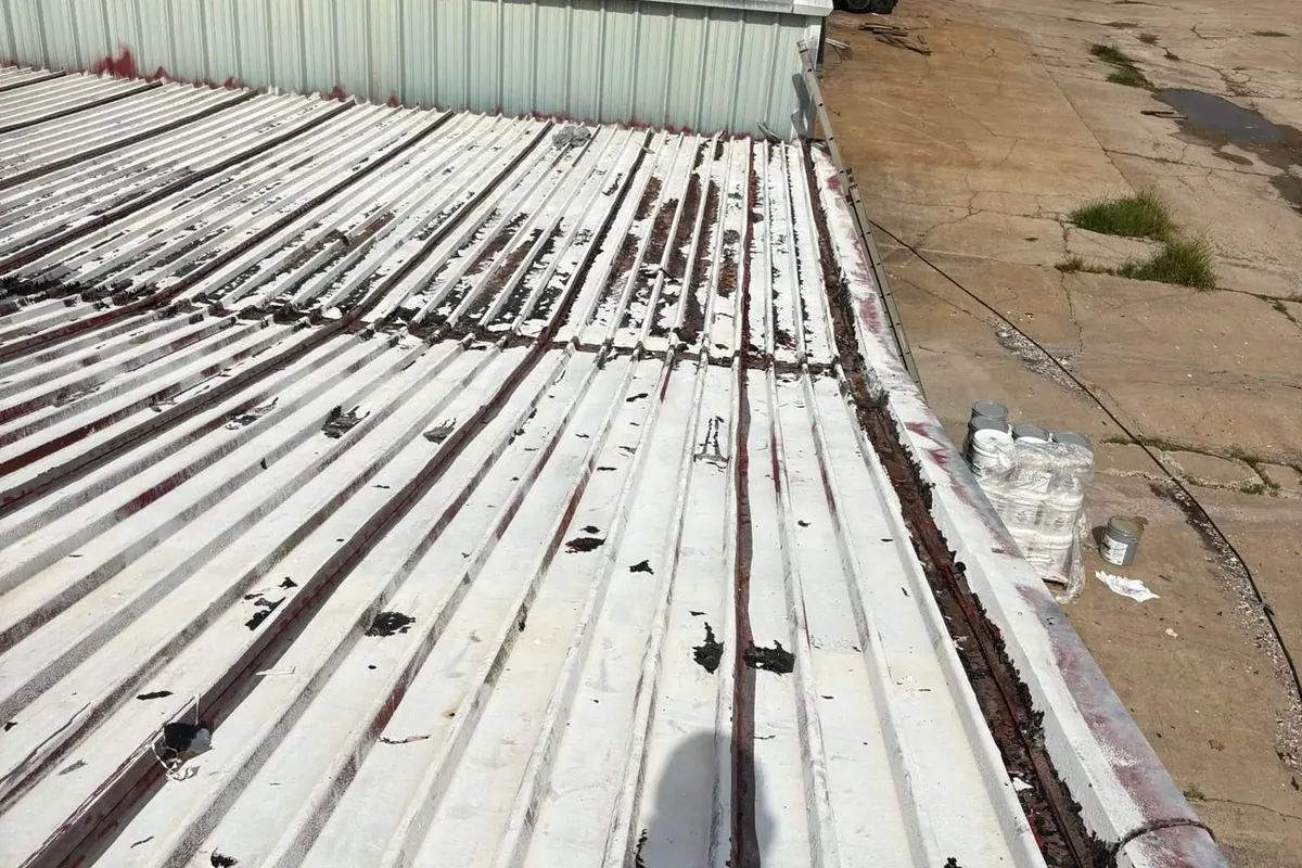 Commercial corrugated metal roof partly coated, peeling sections, C&A Roofing & Construction