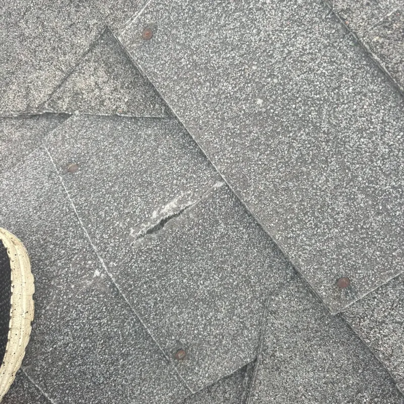 Close-up of torn gray asphalt shingle, C&A Roofing & Construction