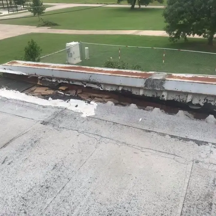 Flat roof edge with torn membrane and damaged parapet, C&A Roofing & Construction