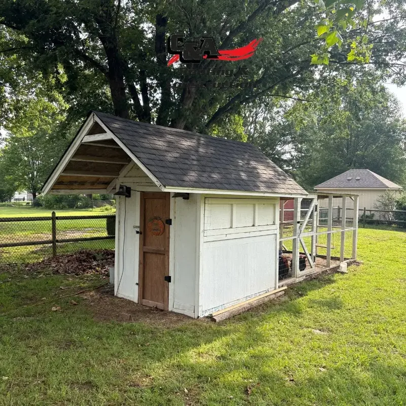 Small white shed with new asphalt shingle roof in yard, C&A Roofing & Construction
