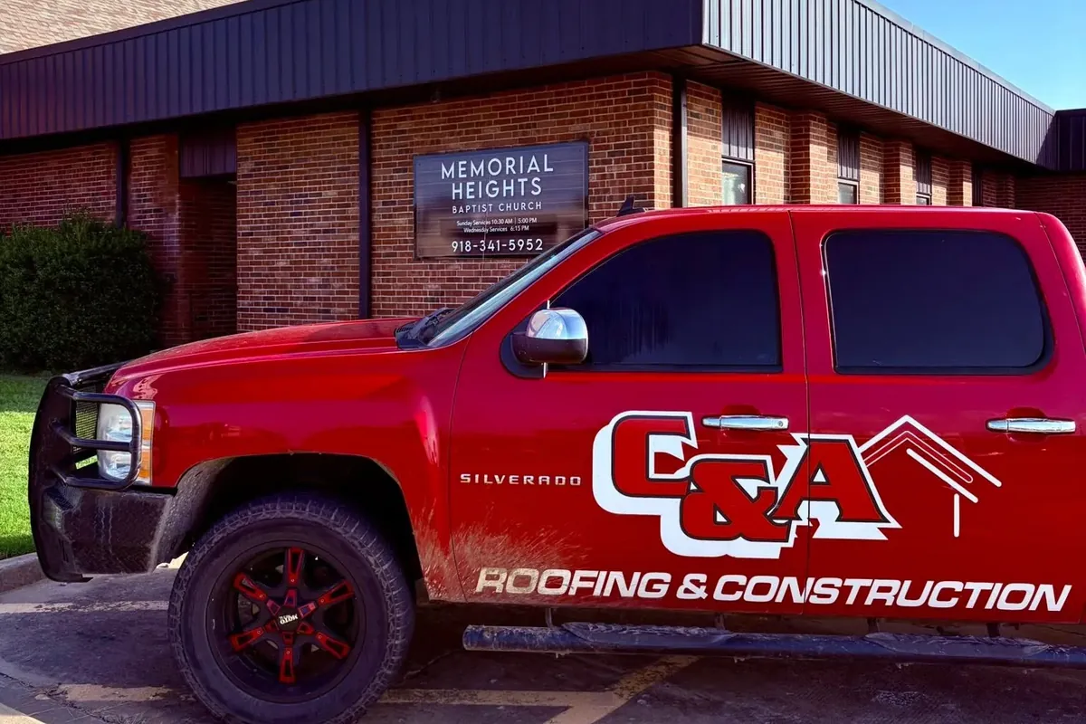 Branded C&A pickup parked at brick church office, C&A Roofing & Construction