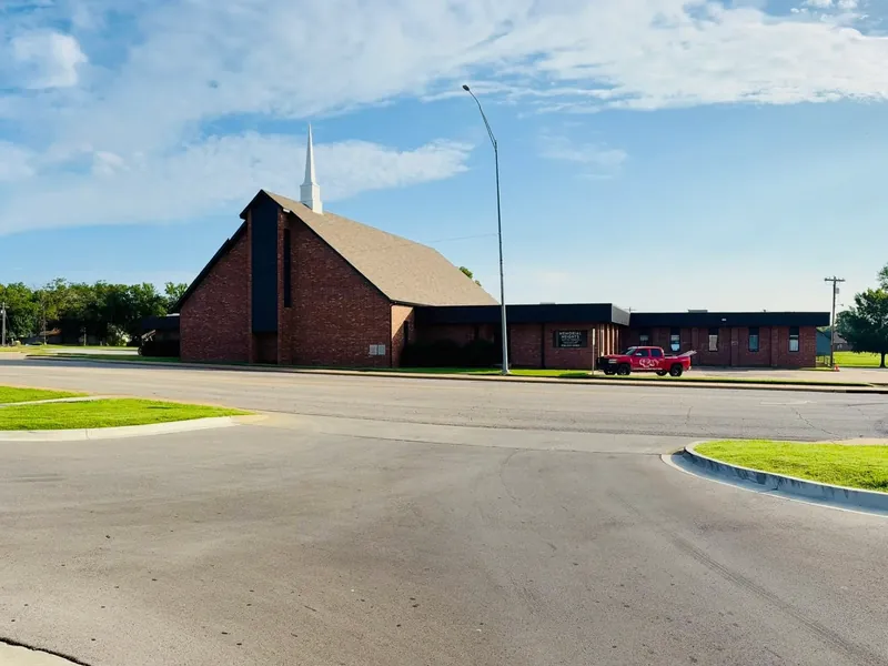 Wide shot of brick church with new shingle roof, C&A truck, C&A Roofing & Construction