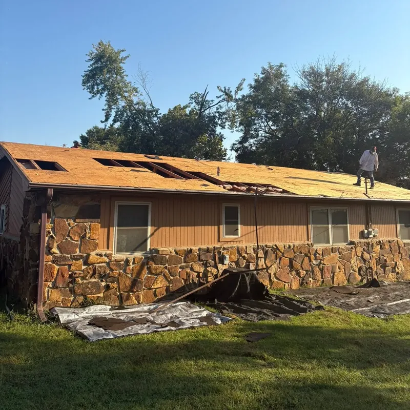 Stone ranch house with roof stripped to decking, C&A Roofing & Construction