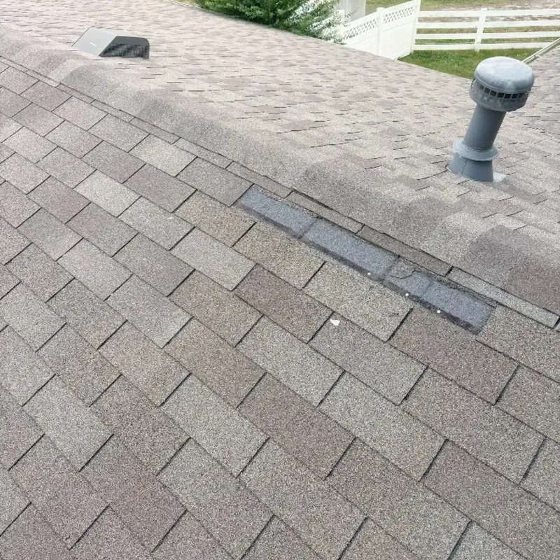 Gray shingle roof with damaged ridge vent and pipe vent, C&A Roofing & Construction