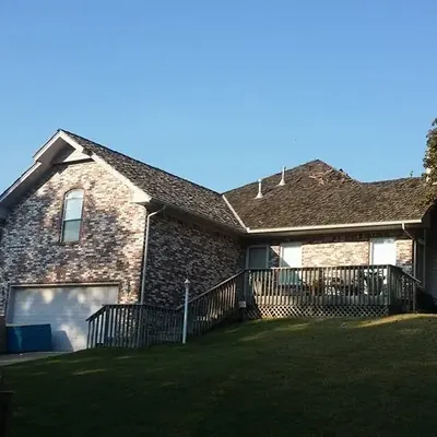 Brick house with shingle roof from backyard, C&A Roofing & Construction