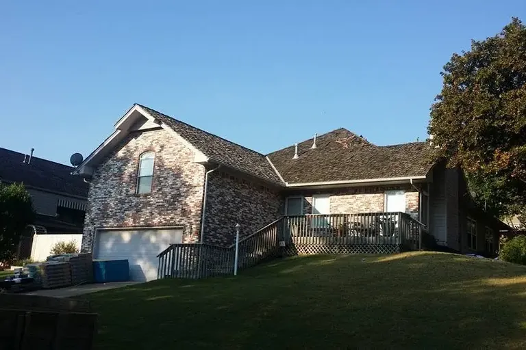 Brick house with shingle roof from backyard, C&A Roofing & Construction