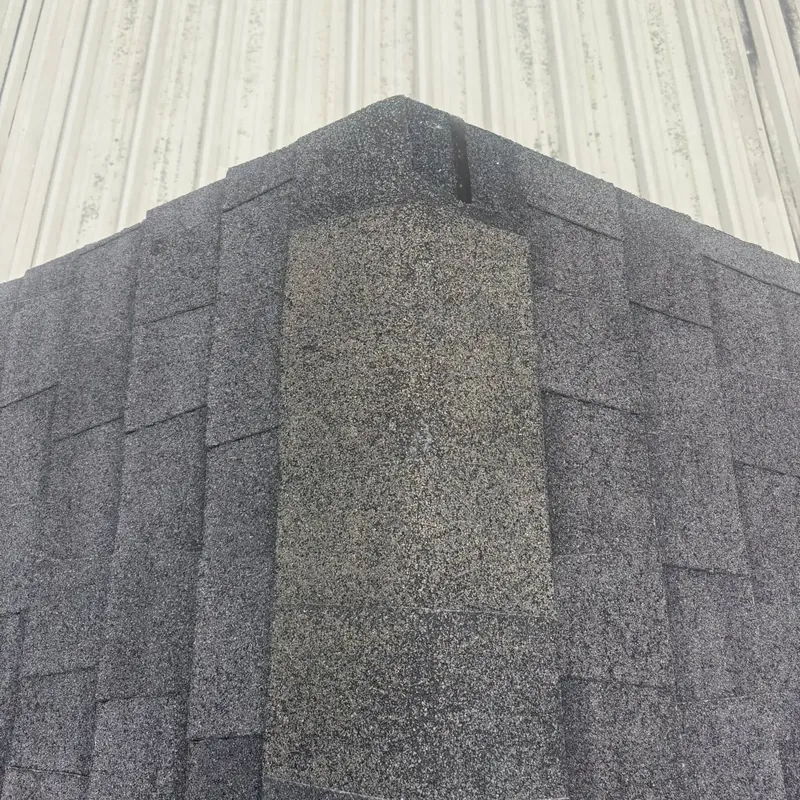 Dark shingle ridge cap with metal roof behind, C&A Roofing & Construction