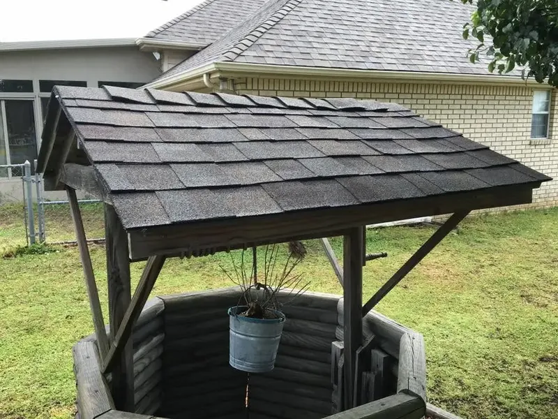 Backyard wishing well with dark shingle roof, C&A Roofing & Construction