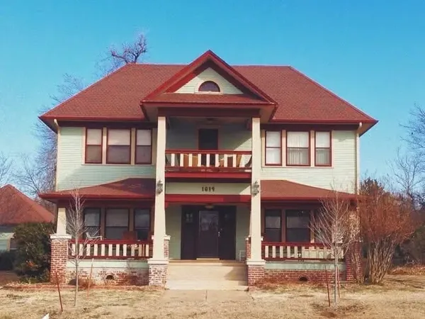 Two-story historic light green house with red shingle roof, C&A Roofing & Construction