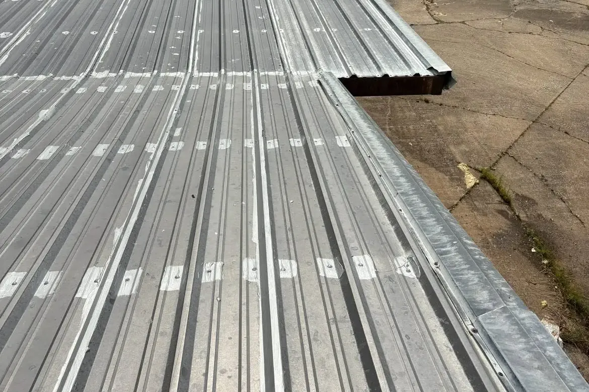 New galvanized metal roof panels on long building, C&A Roofing & Construction