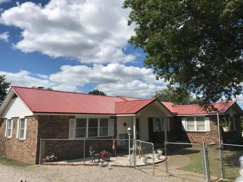Brick ranch house with new red metal roof, C&A Roofing & Construction
