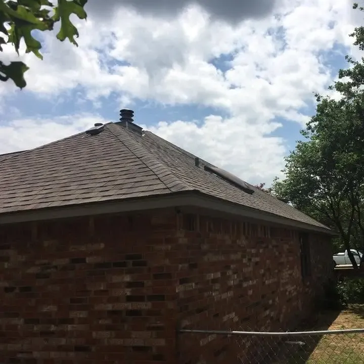 Corner of brick house with new shingle roof and vent, C&A Roofing & Construction