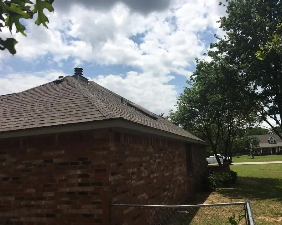 Corner of brick house with new shingle roof and vent, C&A Roofing & Construction