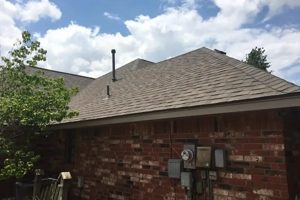 Brick house with new shingle roof, close side view, C&A Roofing & Construction