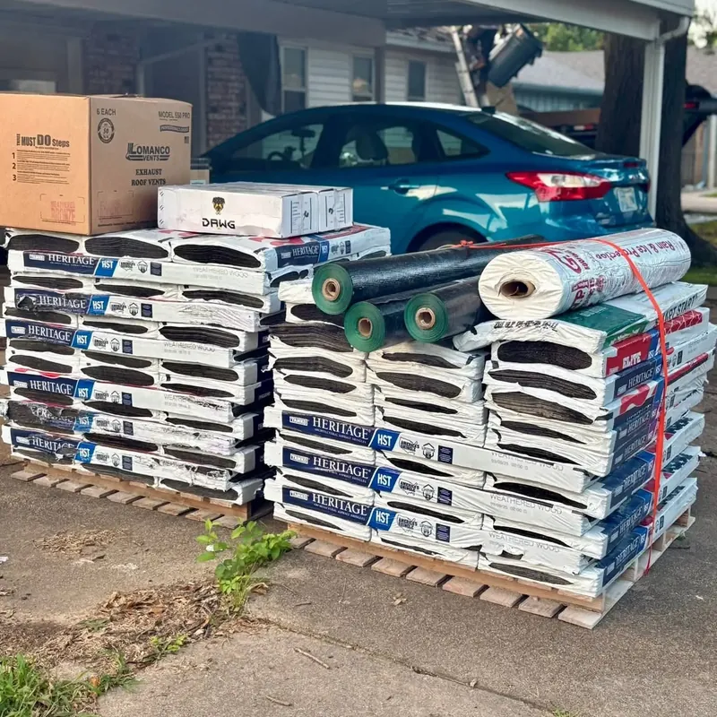 Pallets of shingle bundles and underlayment under carport, C&A Roofing & Construction
