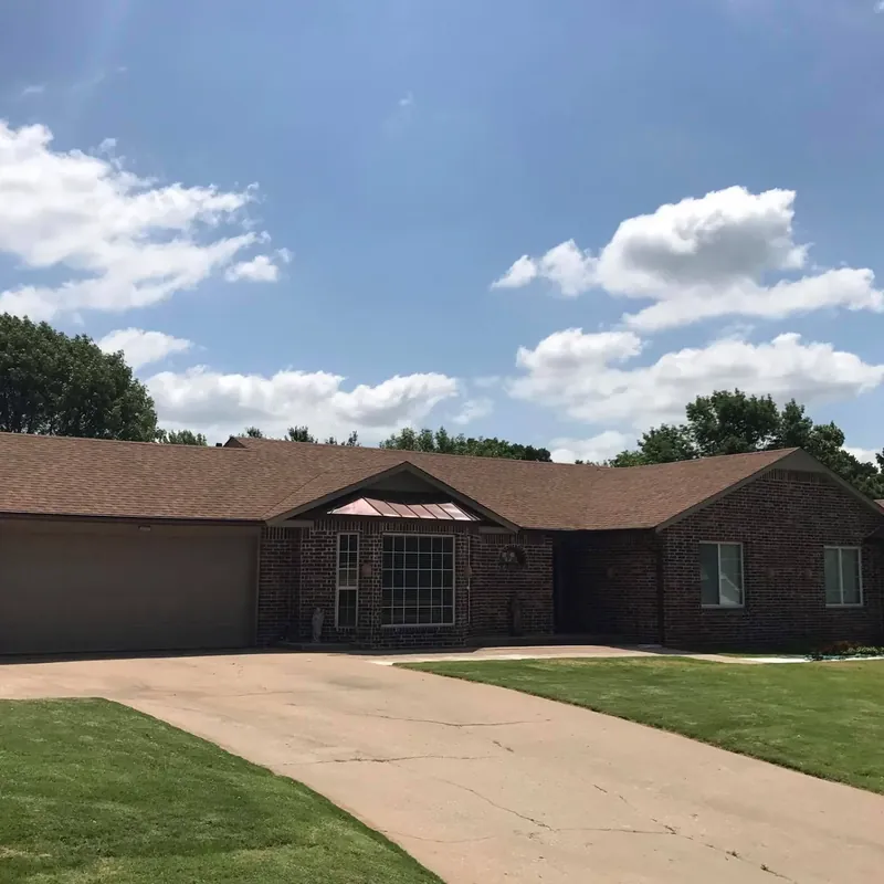 Long brick ranch with brown shingle roof and driveway, C&A Roofing & Construction