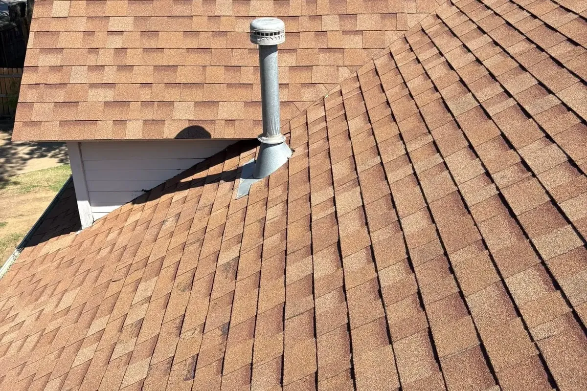 Close-up of brown shingle roof with pipe vent, C&A Roofing & Construction
