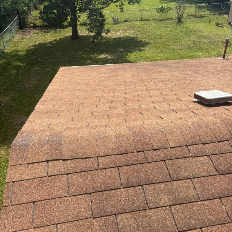 Brown shingle roof edge with yard beyond, C&A Roofing & Construction