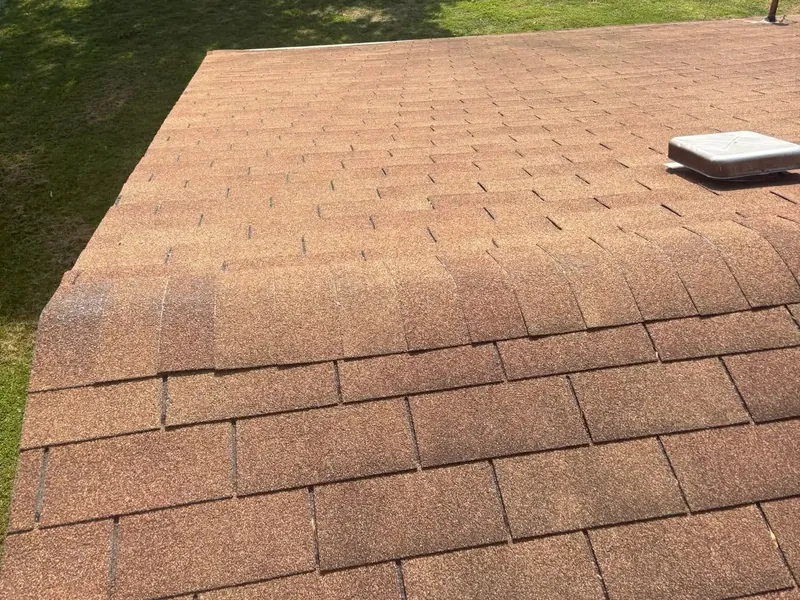 Brown shingle roof edge with yard beyond, C&A Roofing & Construction