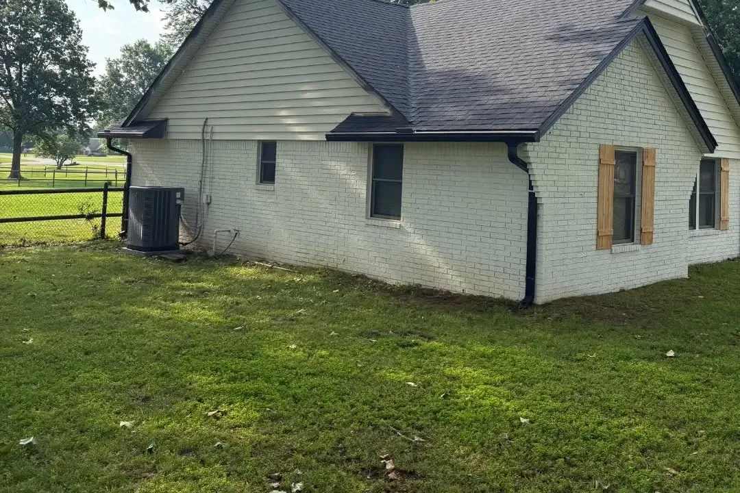White farmhouse with new dark shingle roof, C&A Roofing & Construction
