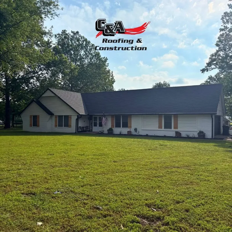 White ranch house with dark shingle roof across lawn, C&A Roofing & Construction