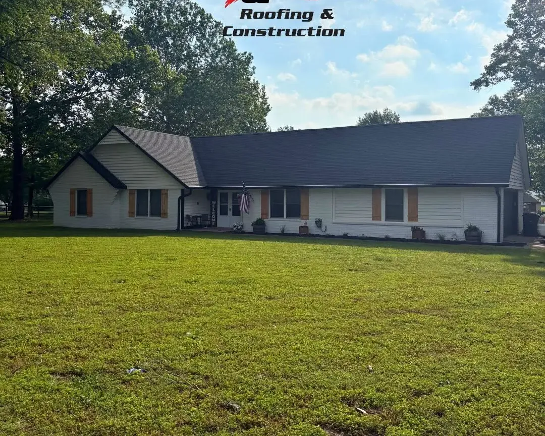 White ranch house with dark shingle roof across lawn, C&A Roofing & Construction