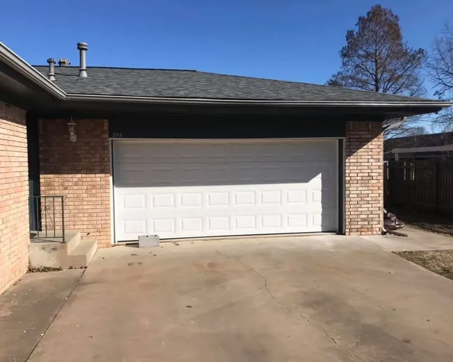 Brick house garage with dark shingle roof, C&A Roofing & Construction