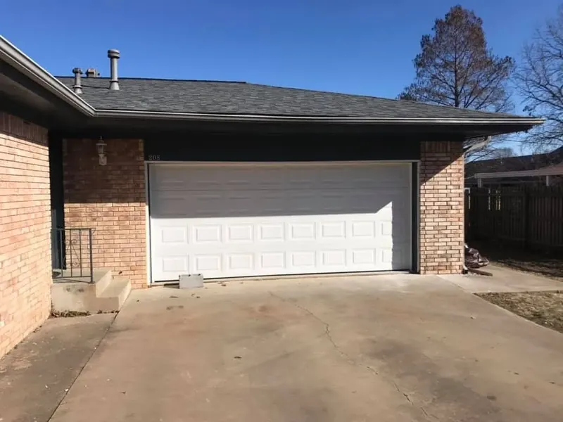 Brick house garage with dark shingle roof, C&A Roofing & Construction