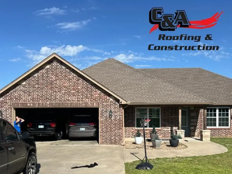 Brick house with brown shingle roof and open garage, C&A Roofing & Construction