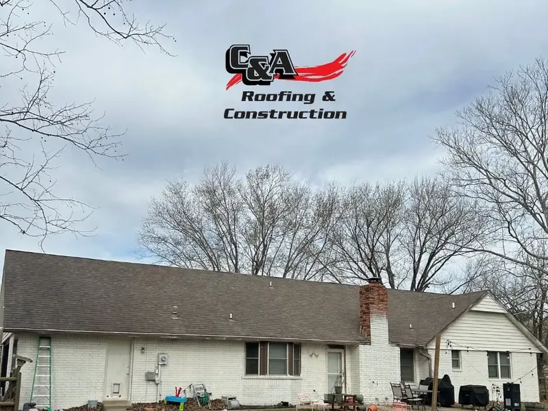 White ranch house with shingle roof and chimney, C&A Roofing & Construction