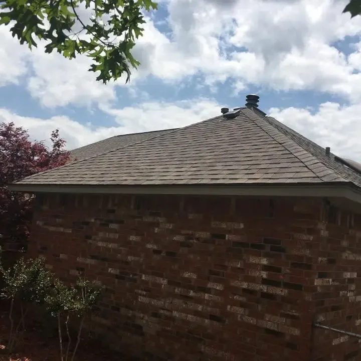 Brick house corner with new shingle roof and vents, C&A Roofing & Construction