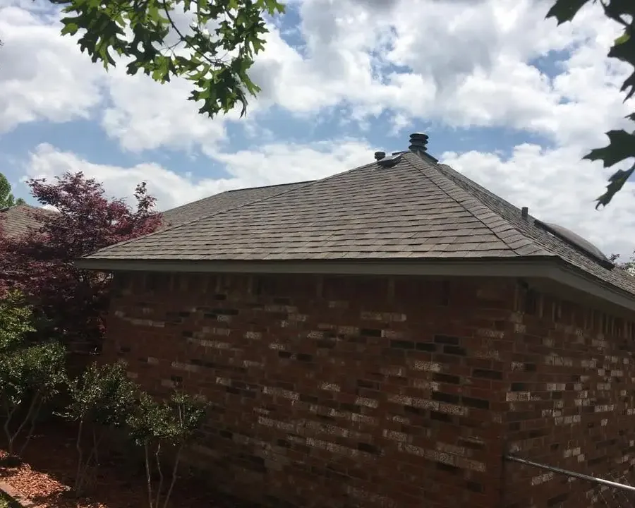 Brick house corner with new shingle roof and vents, C&A Roofing & Construction