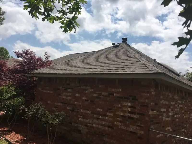 Brick house corner with new shingle roof and vents, C&A Roofing & Construction