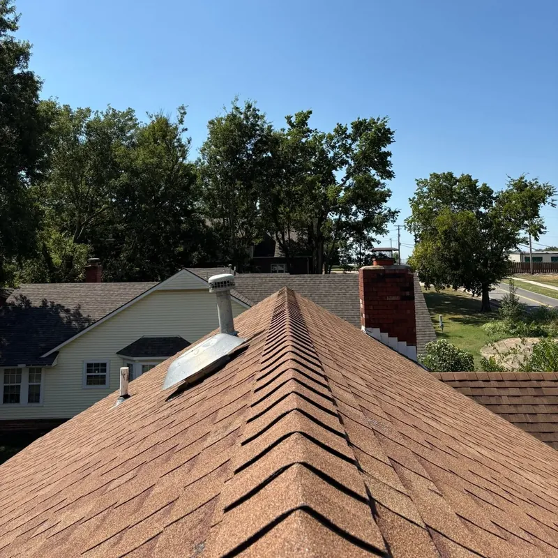 Shingle roof ridge with chimney over neighborhood, C&A Roofing & Construction
