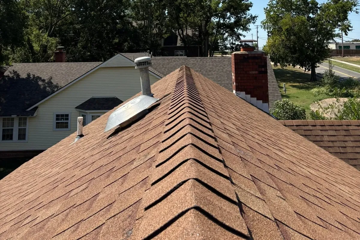 Shingle roof ridge with chimney over neighborhood, C&A Roofing & Construction