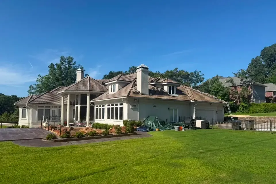 Stucco home with tile roof seen across lawn, C&A Roofing & Construction