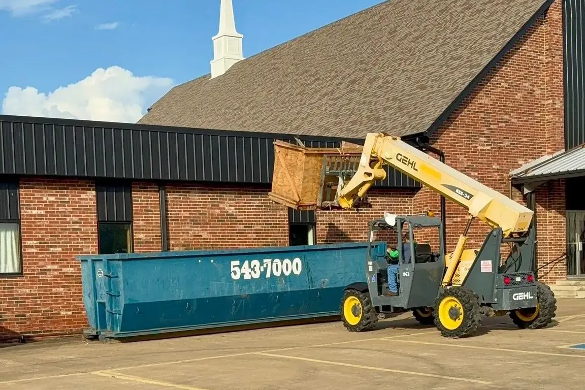Telehandler and dumpster at brick church with steeple, C&A Roofing & Construction