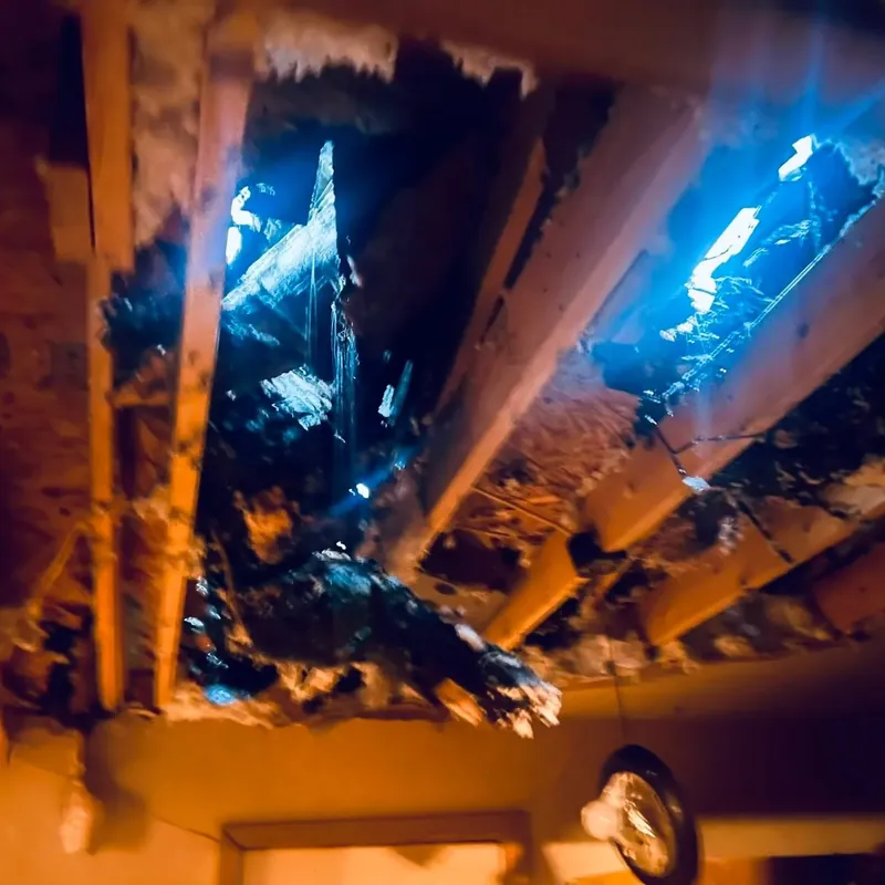 Damaged ceiling with holes showing daylight through roof, C&A Roofing & Construction