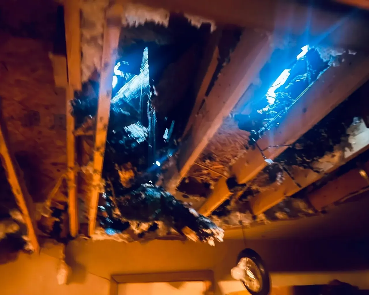 Damaged ceiling with holes showing daylight through roof, C&A Roofing & Construction